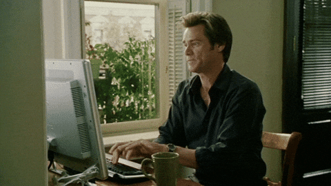 Jim Carrey types frantically on his computer's keyboard